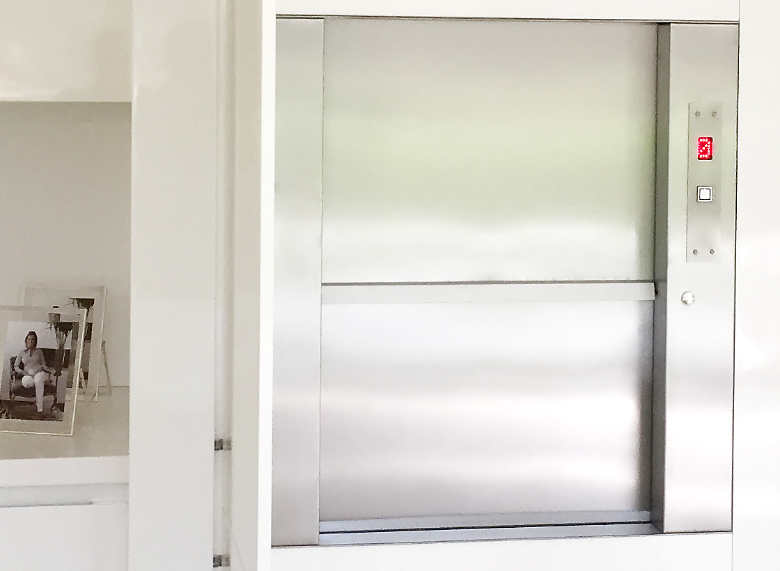 Малый грузовой лифт SKG ISO-A 50 кг. инсталлированный в мебельный гарнитур кухни загородного дома.